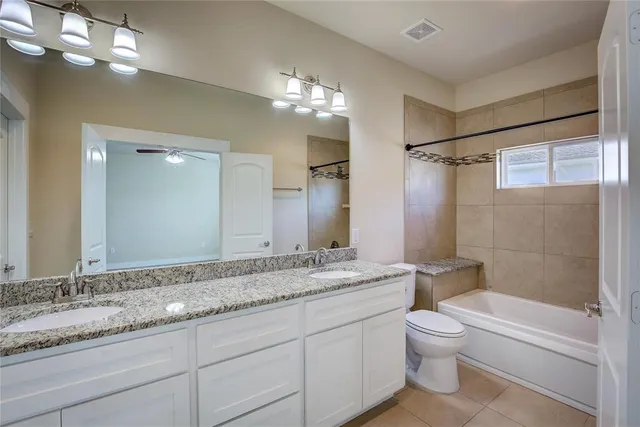 a bathroom with a granite countertop sink a toilet and shower