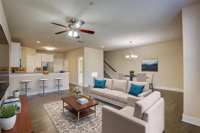 a living room with furniture and a dining table with kitchen view
