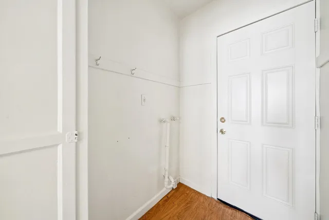 an empty room with windows and refrigerator