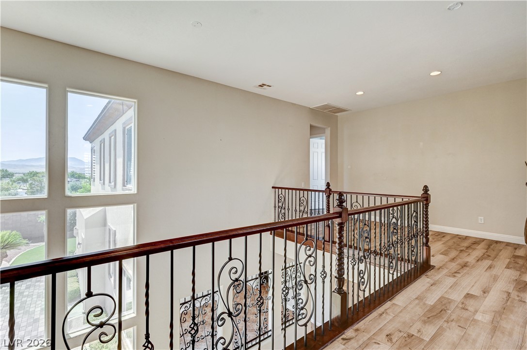 2793 Rosenhearty Drive Henderson, NV 89044 - Photo 36 of 77 Ornate wrought iron railings add a touch of elegance to this upper-level hallway with large, light-filled windows.