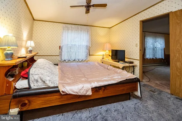 a bed sitting in a bedroom next to a window and a chandelier