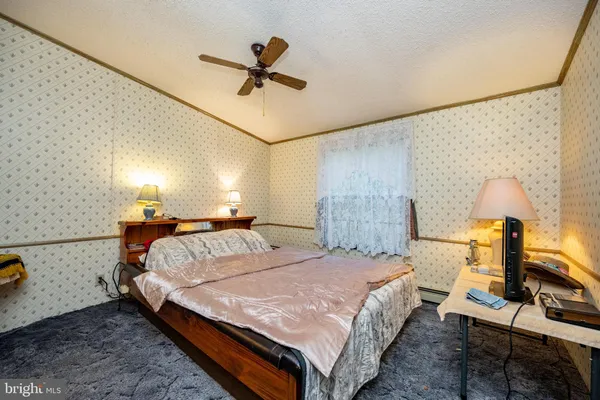a bedroom with a bed and a potted plant on the dresser
