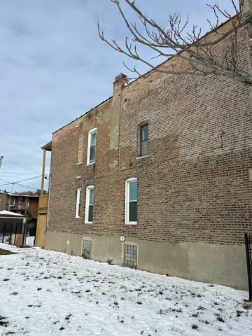 a brick building with a view of a backyard