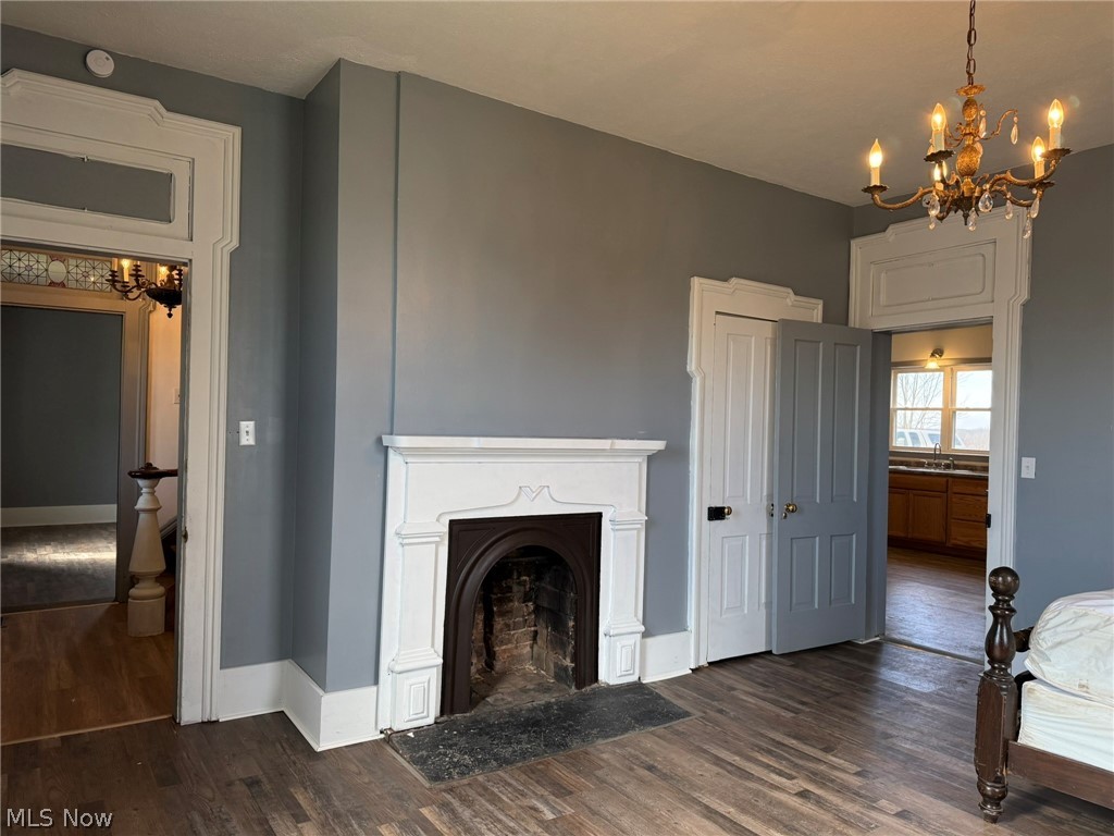 23033 Cadiz Road Freeport, OH 43973 - Photo 12 of 31 Living room featuring a chandelier, dark wood finished floors, and a fireplace with flush hearth