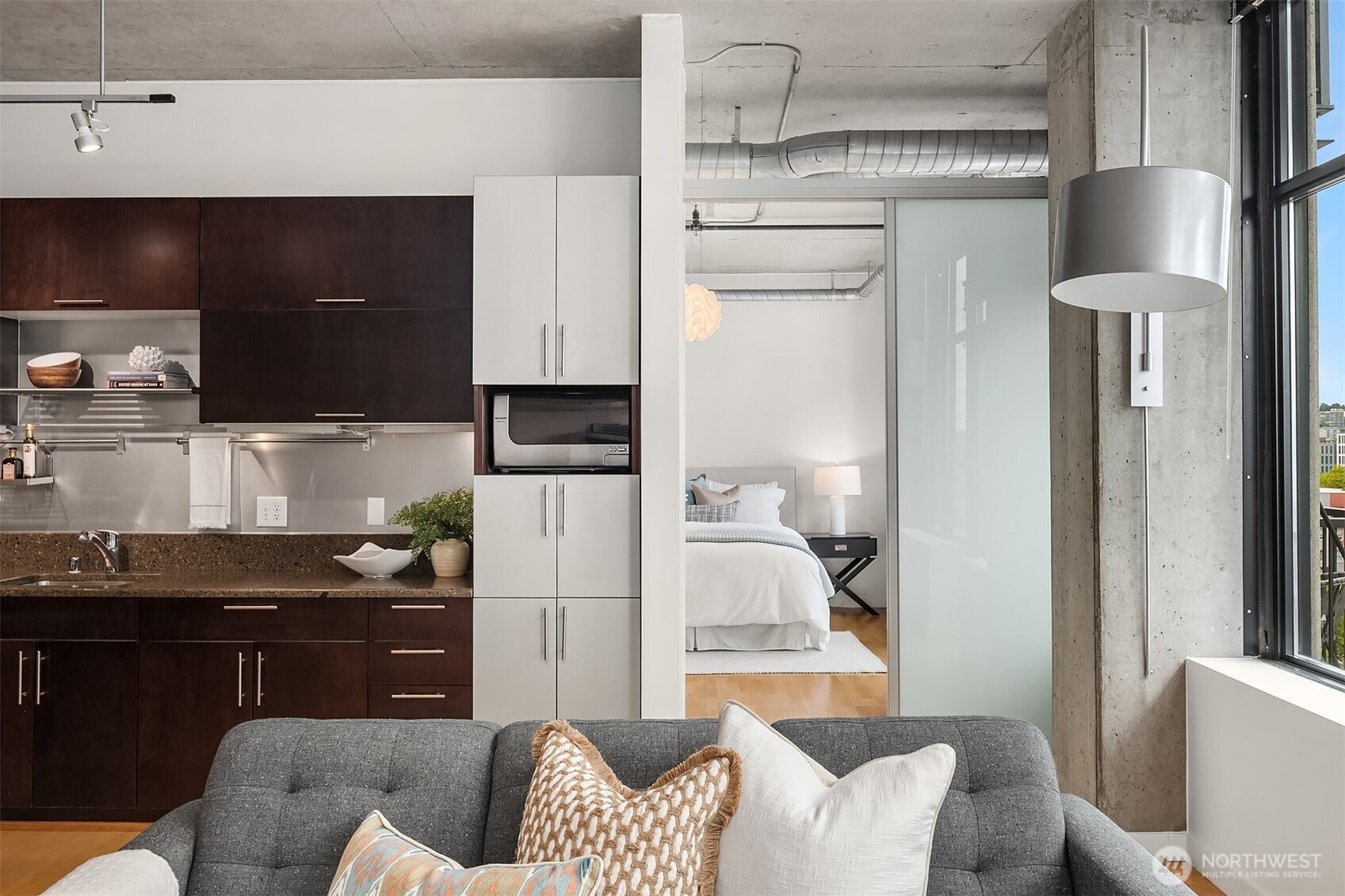 2720 3rd Avenue, Unit 909 Seattle, WA 98121 - Photo 25 of 40 a kitchen with stainless steel appliances kitchen island granite countertop a refrigerator and a stove top oven