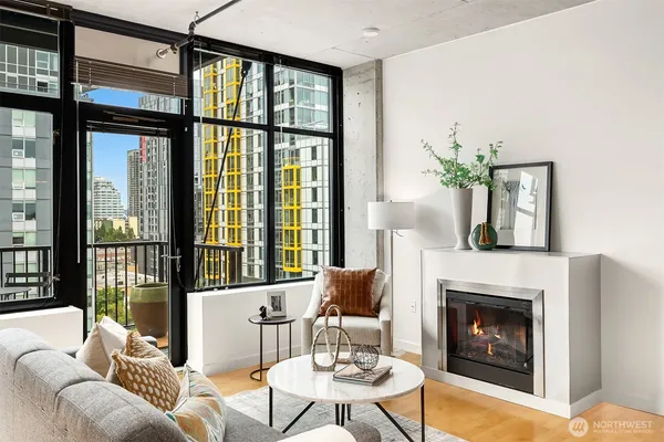 a living room with furniture a fireplace and a floor to ceiling windows