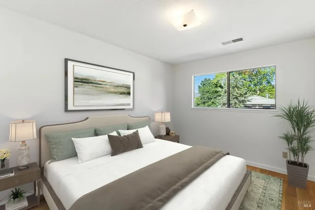 a bedroom with a large bed and a potted plant