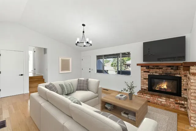 a living room with furniture a flat screen tv and a fireplace