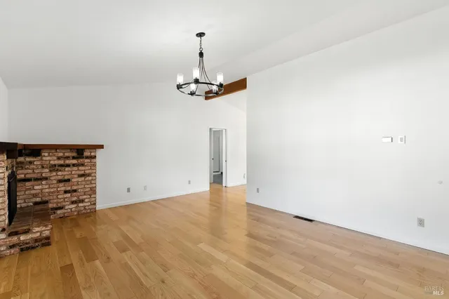 a open kitchen with granite countertop a stove top oven a sink and dishwasher with wooden floor