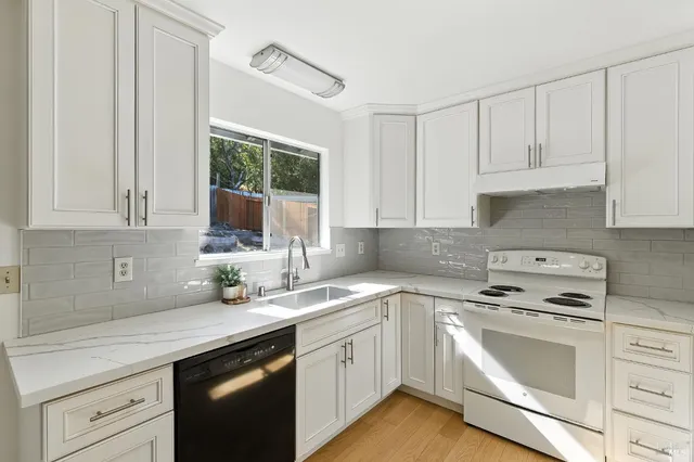 a kitchen with white cabinets sink and white appliances
