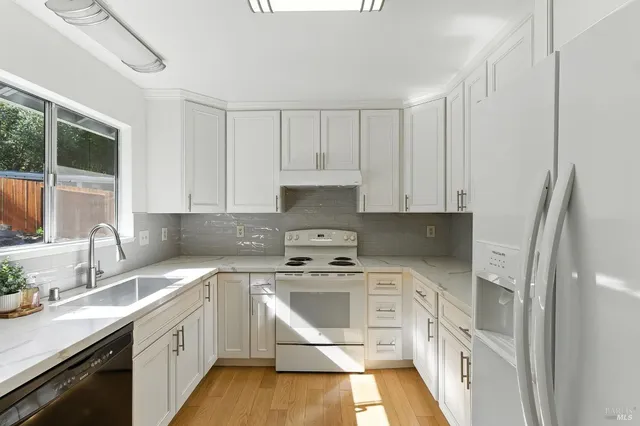 a kitchen with white cabinets sink and white appliances