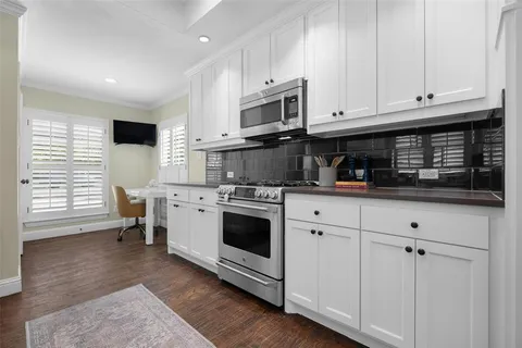 a kitchen with stainless steel appliances white cabinets and a stove top oven