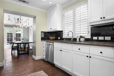 a kitchen with white cabinets and sink