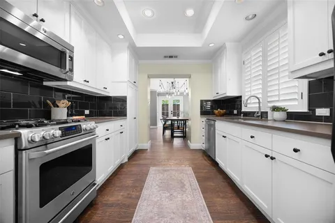 a large kitchen with stainless steel appliances granite countertop a stove a sink and a microwave