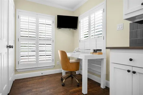 a view of a workspace with furniture and a window