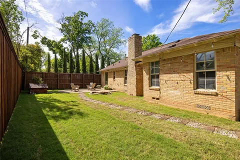 a view of swimming pool with lawn chairs and plants