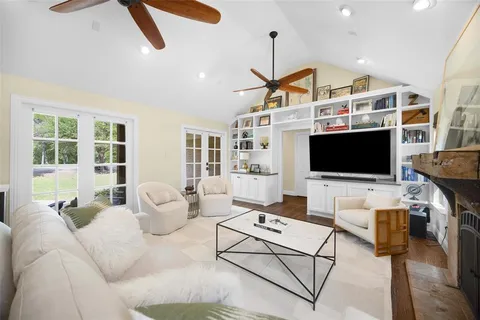 a living room with furniture a flat screen tv and a floor to ceiling window