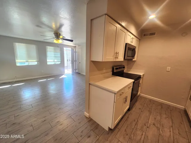 a kitchen with stove and wooden floor