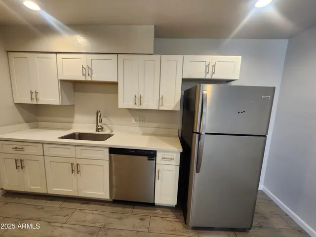 a kitchen with stainless steel appliances a refrigerator and cabinets