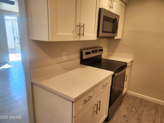 a kitchen with stainless steel appliances a stove microwave and sink