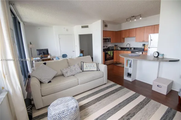 a living room with furniture and a view of kitchen