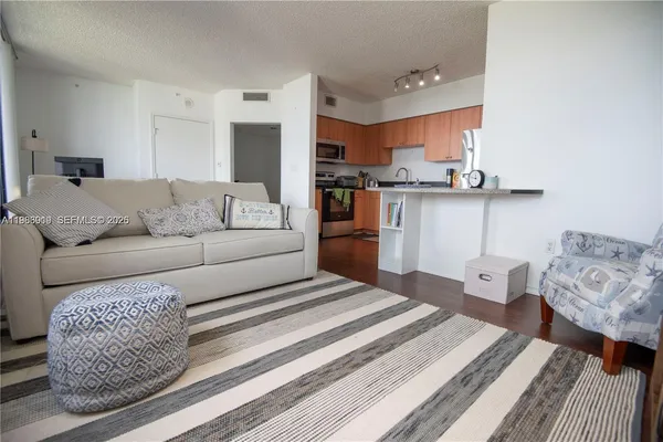 a living room with furniture and a view of kitchen