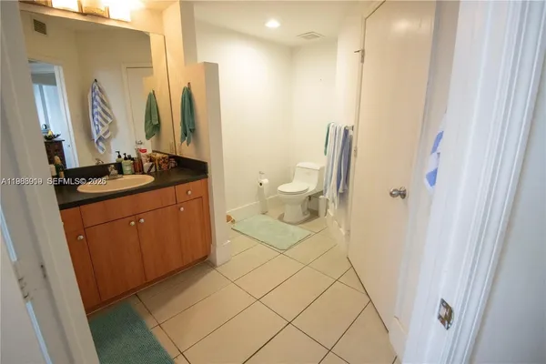 a bathroom with a granite countertop sink a toilet and a mirror