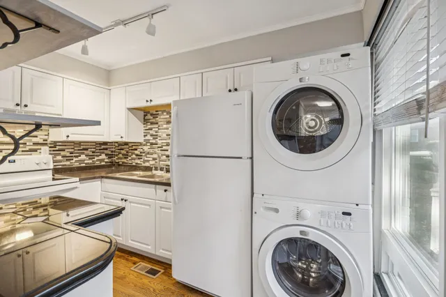a kitchen with a refrigerator sink and cabinets