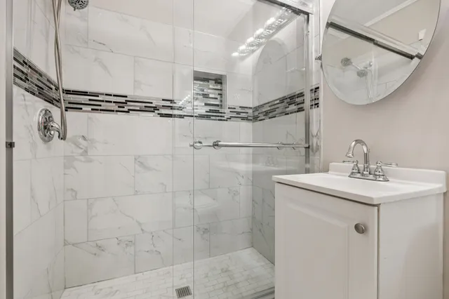 a bathroom with a sink a mirror and shower