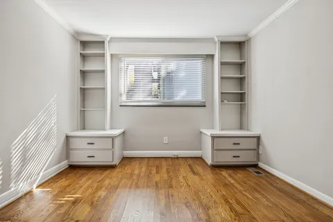 an empty room with cabinet and windows