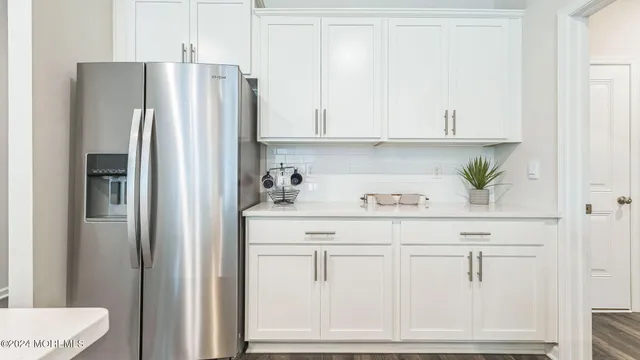 a kitchen with stainless steel appliances white cabinets and a refrigerator