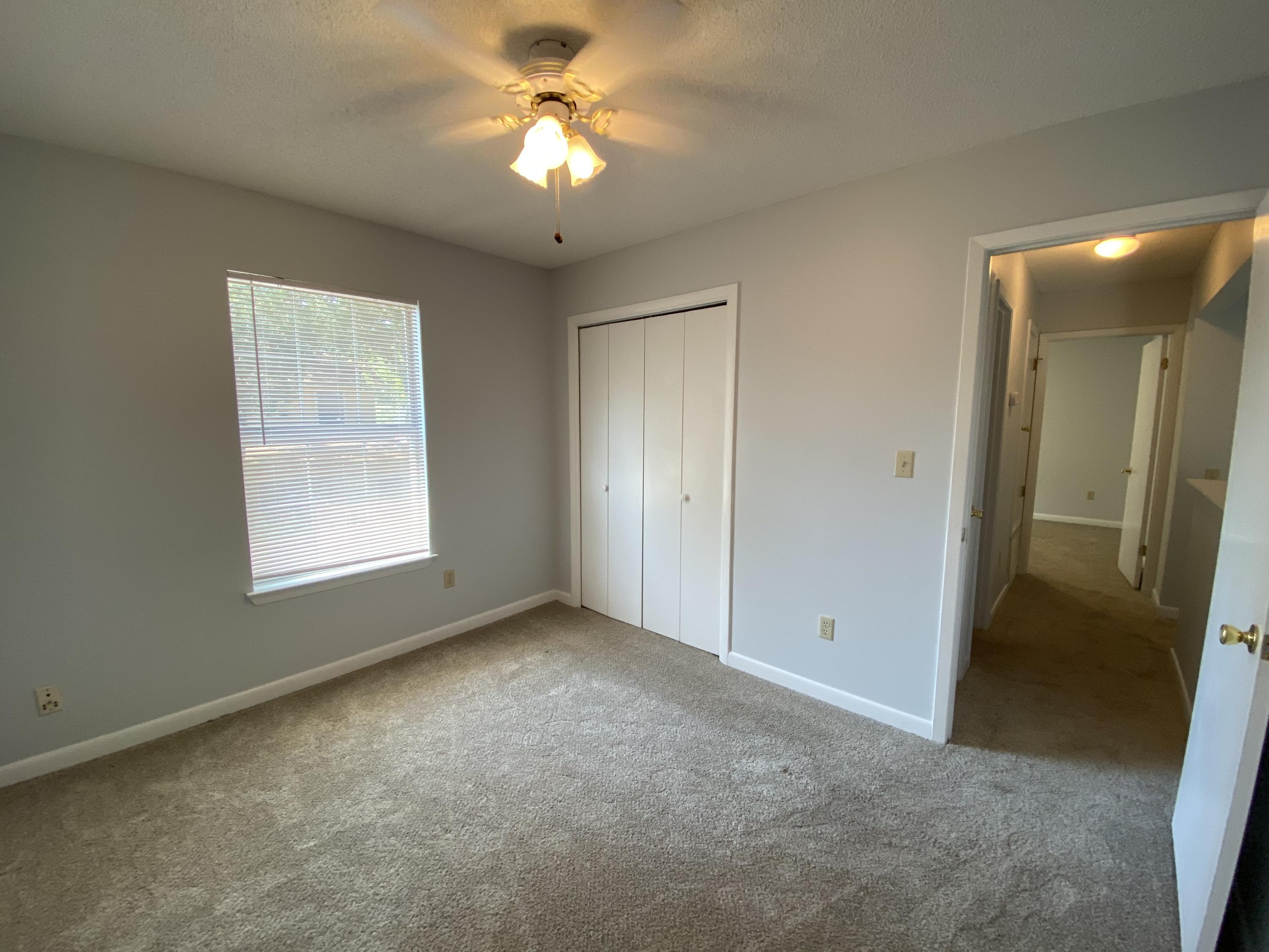 169 Wright Circle Niceville, FL 32578 - Photo 21 of 27 an empty room with a chandelier fan and windows