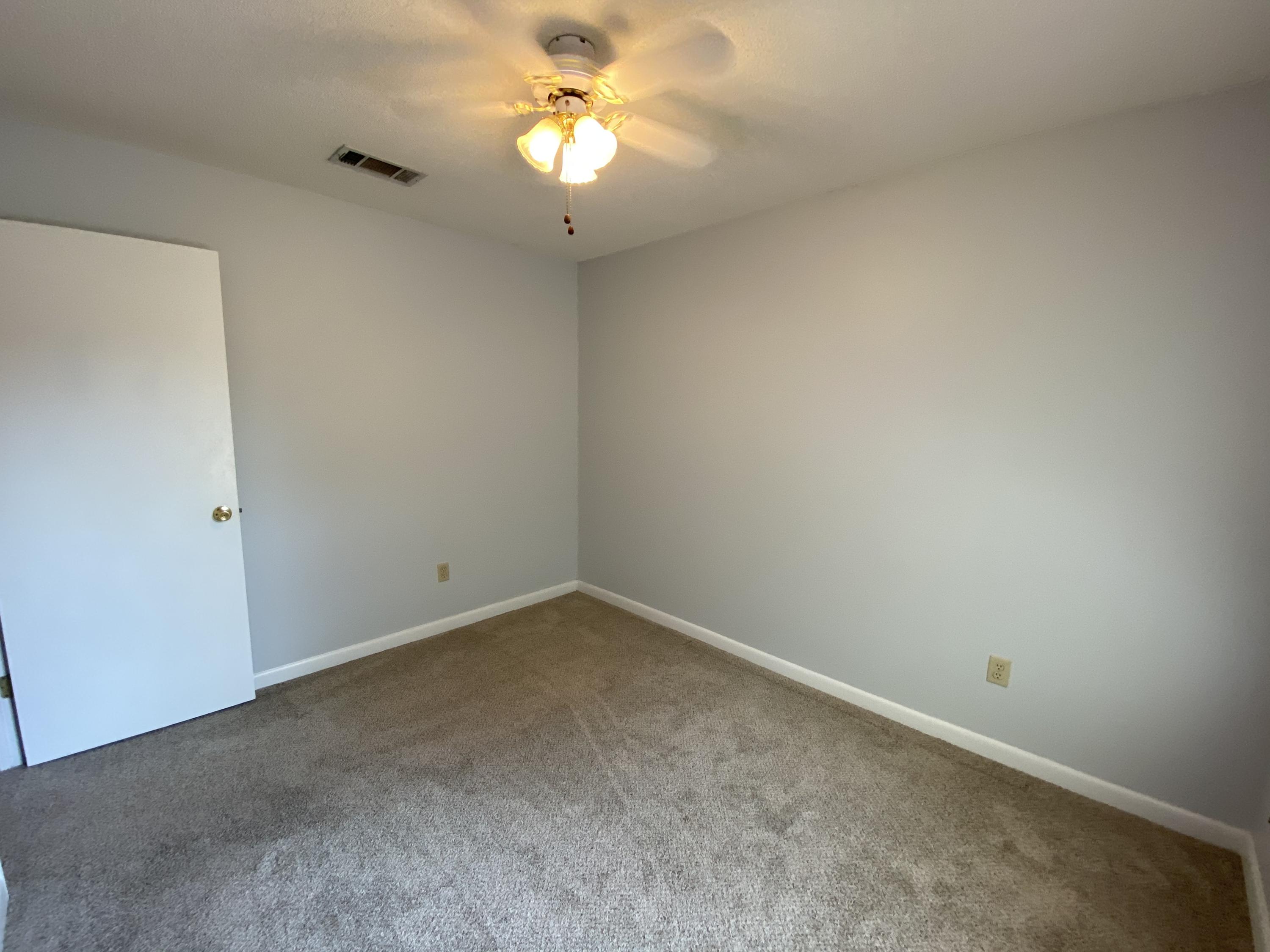 169 Wright Circle Niceville, FL 32578 - Photo 23 of 27 an empty room with a chandelier fan and a ceiling fan