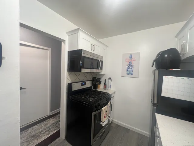 a kitchen with stainless steel appliances a sink stove and cabinets
