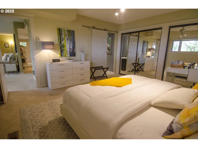 a bedroom with a bed a mirror and dresser