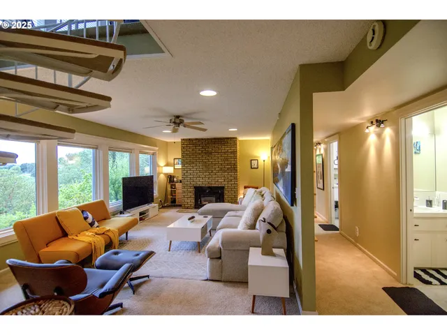 a living room with furniture a large window and a fireplace