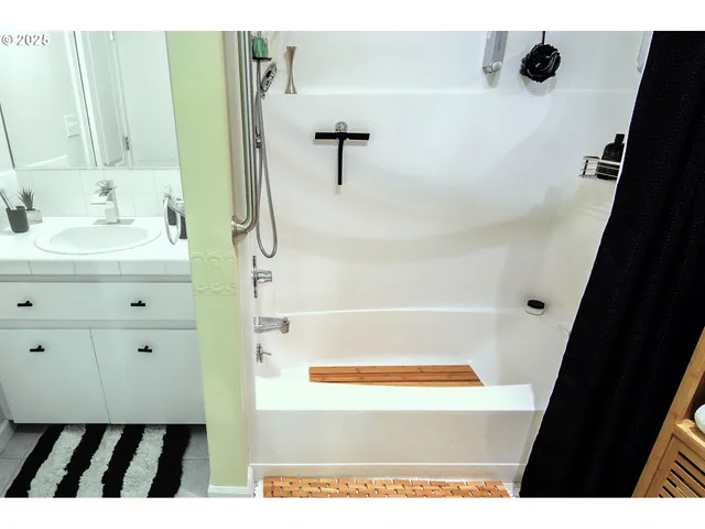 a bathroom with a tub sink and mirror