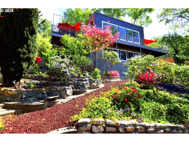 a view of a wooden house with a flower garden