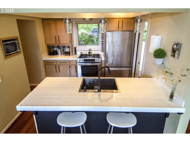 a kitchen with stainless steel appliances a sink a table and chairs