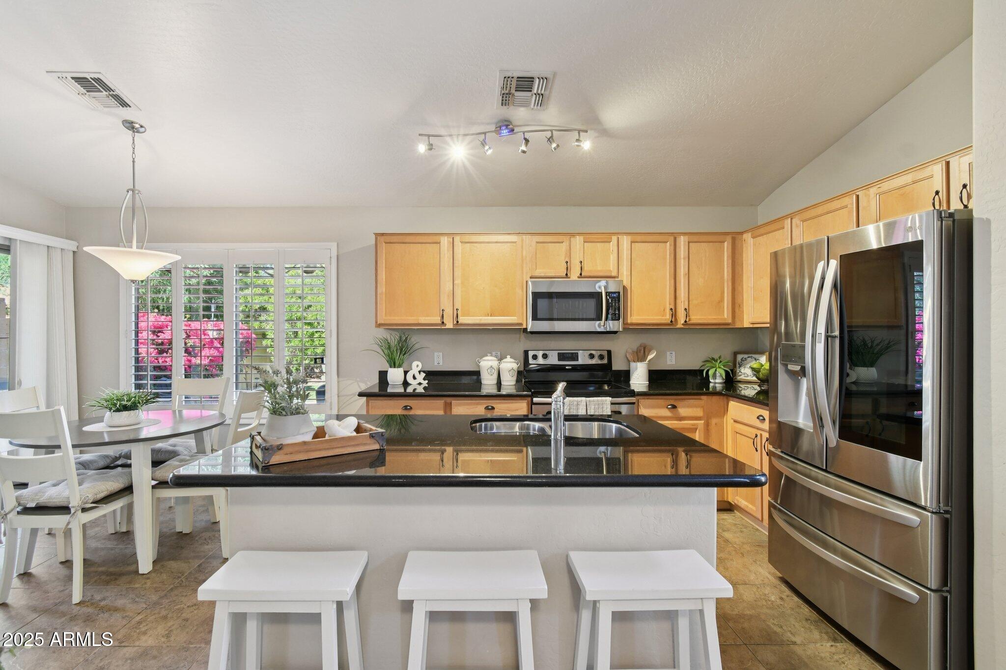 2250 East Deer Valley Drive, Unit 109 Phoenix, AZ 85024 - Photo 15 of 20 a kitchen with stainless steel appliances granite countertop a refrigerator and a stove top oven