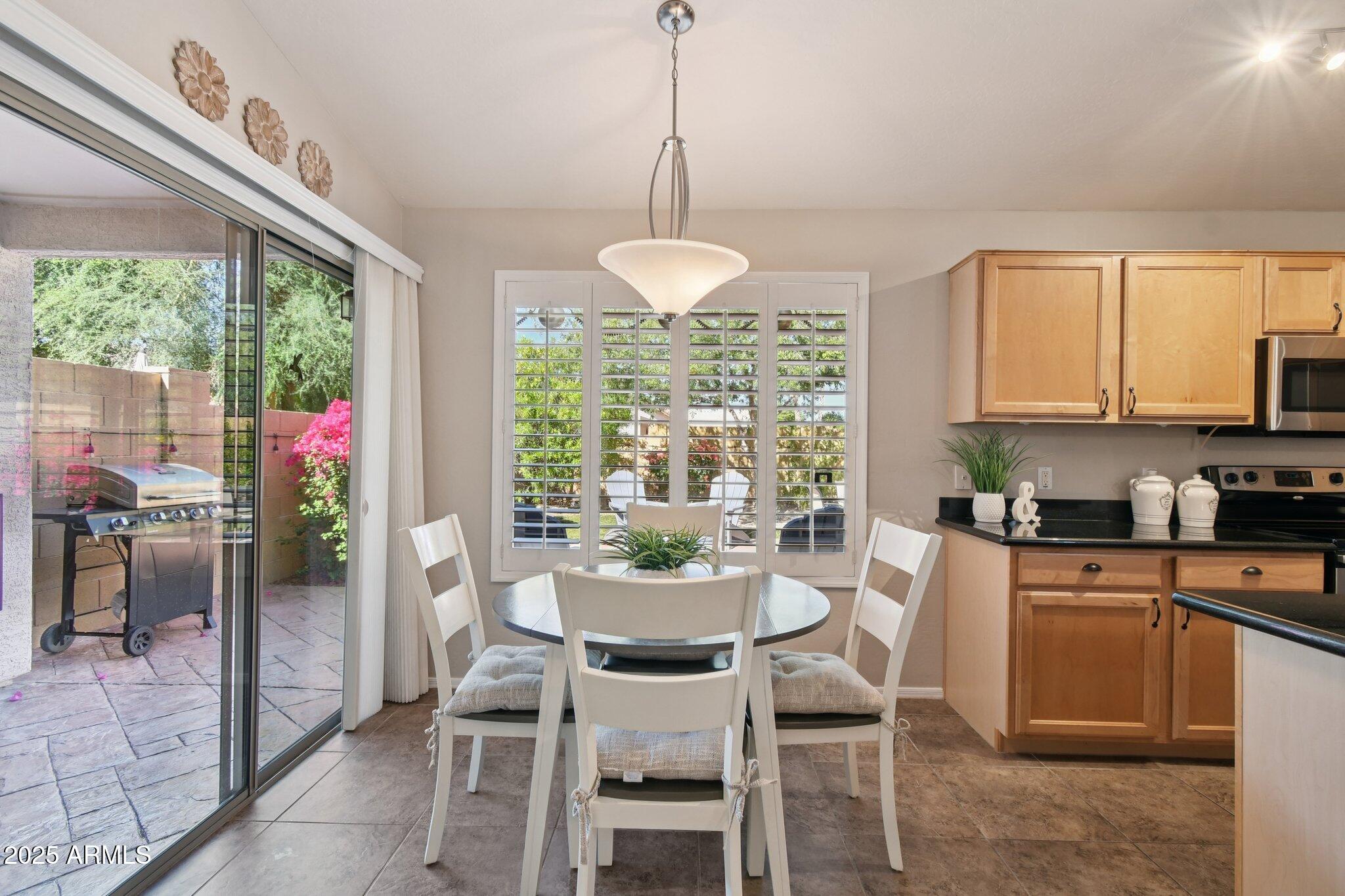 2250 East Deer Valley Drive, Unit 109 Phoenix, AZ 85024 - Photo 16 of 20 a dining room with furniture a chandelier and wooden floor
