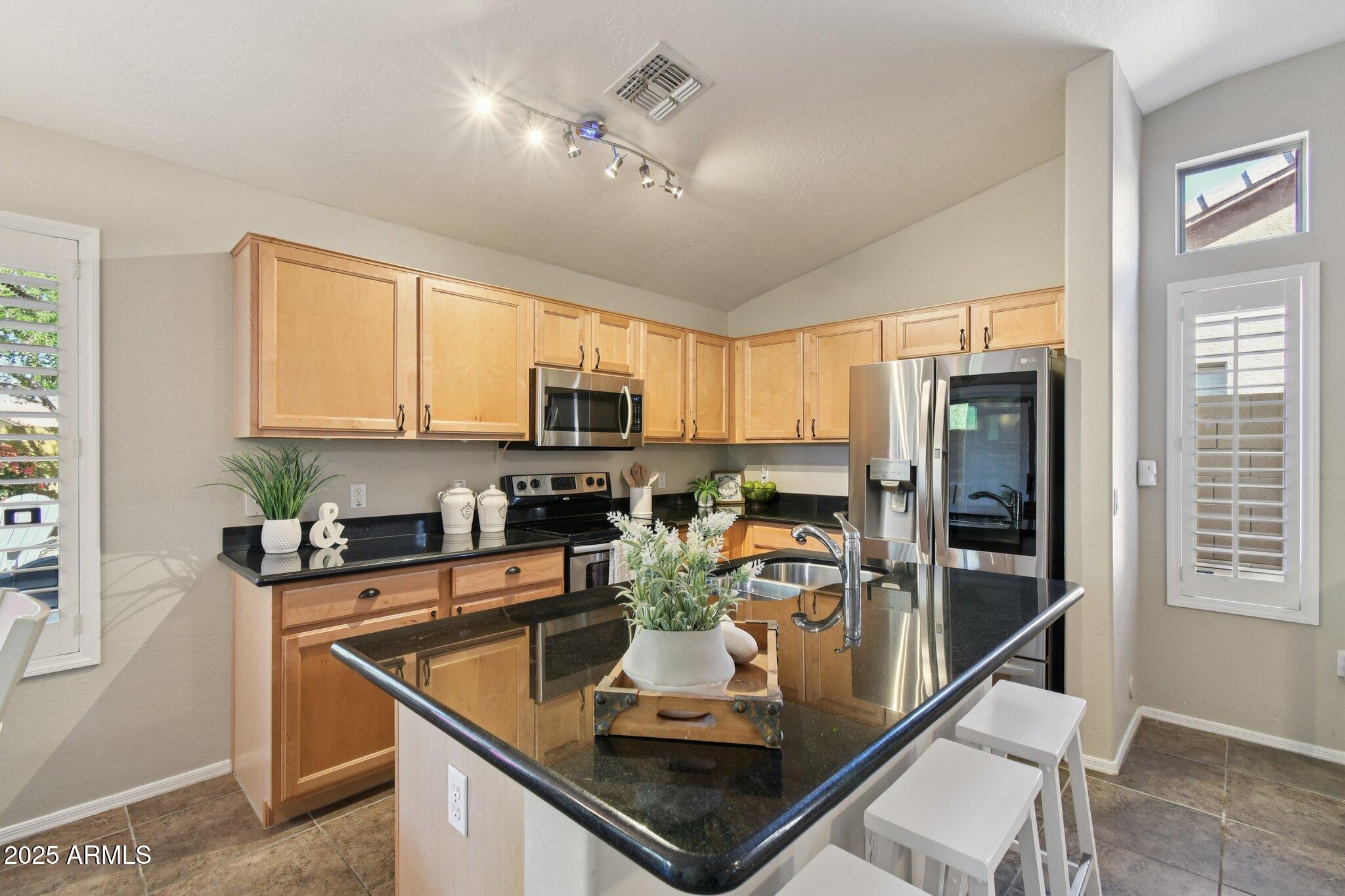 2250 East Deer Valley Drive, Unit 109 Phoenix, AZ 85024 - Photo 17 of 20 a kitchen with stainless steel appliances granite countertop a sink stove and refrigerator