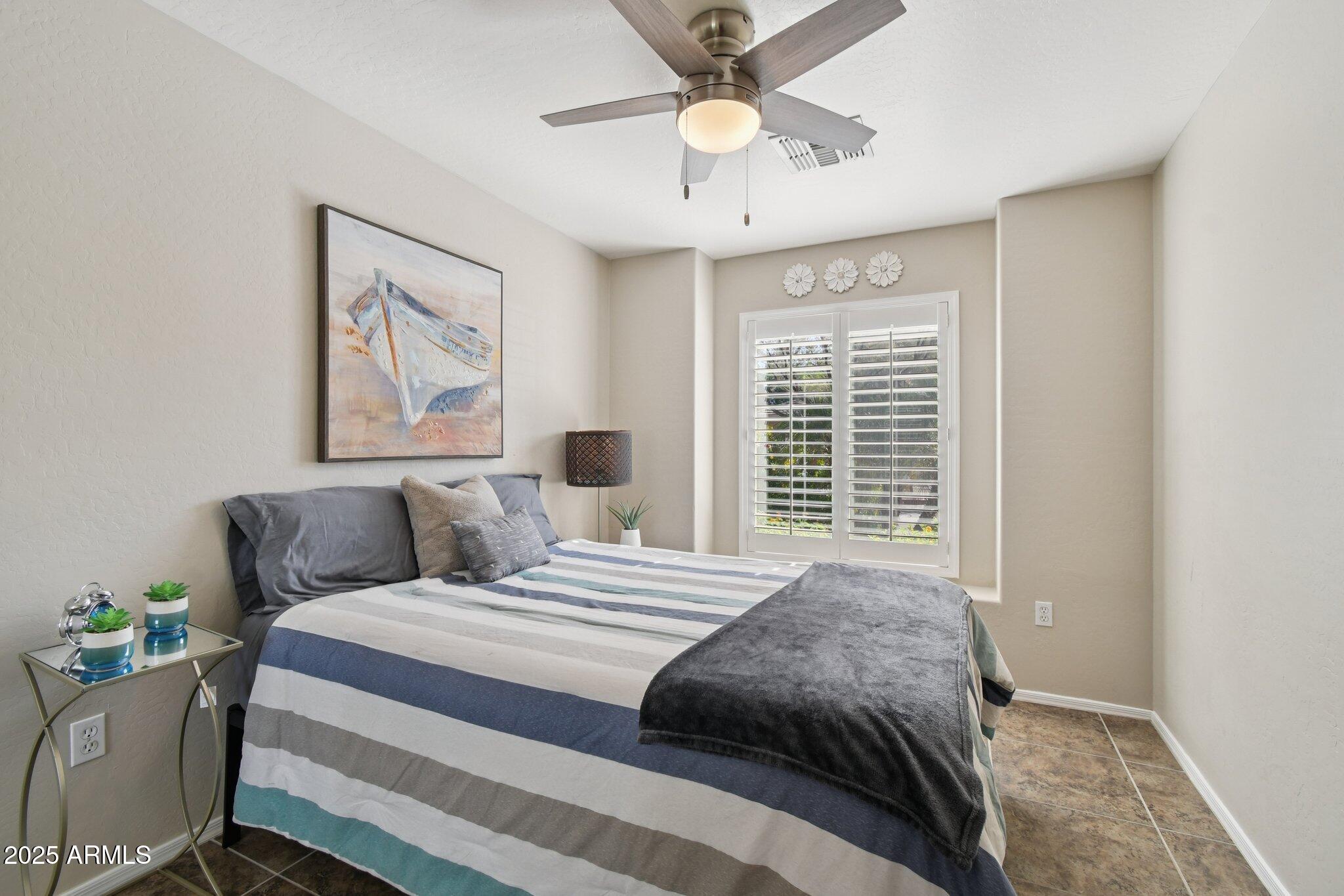 2250 East Deer Valley Drive, Unit 109 Phoenix, AZ 85024 - Photo 8 of 20 a bedroom with a bed and a chandelier