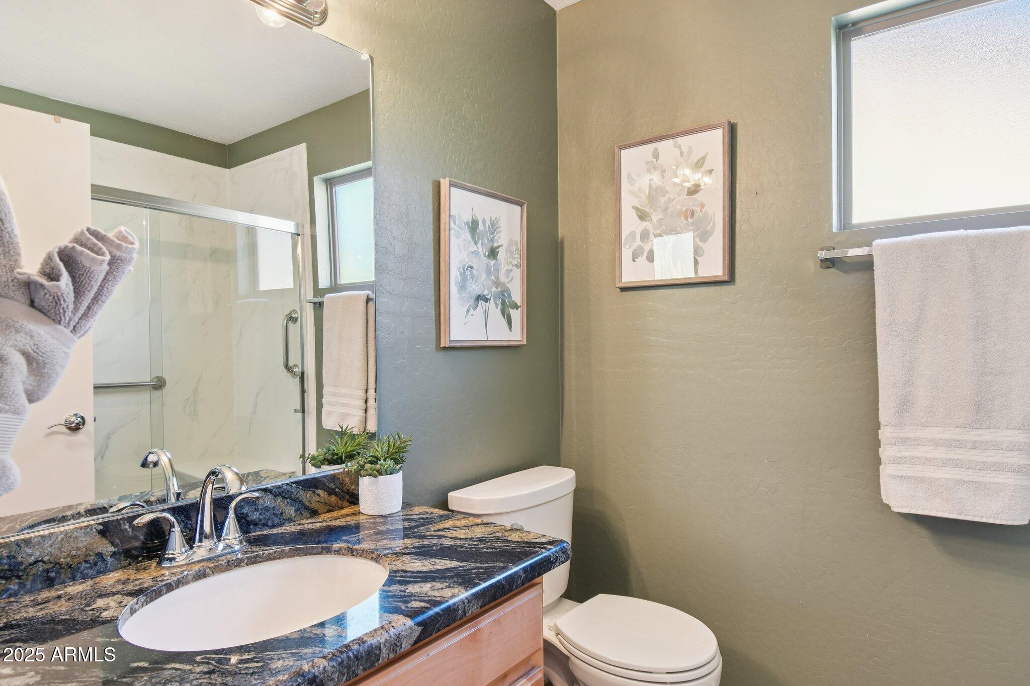 2250 East Deer Valley Drive, Unit 109 Phoenix, AZ 85024 - Photo 9 of 20 a bathroom with a granite countertop toilet sink and mirror