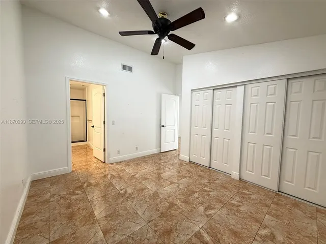 an empty room with fan and windows