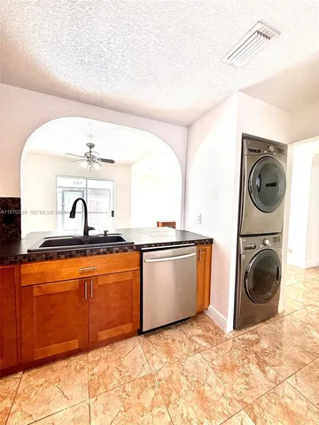 a view of a kitchen with a sink and a washer dryer