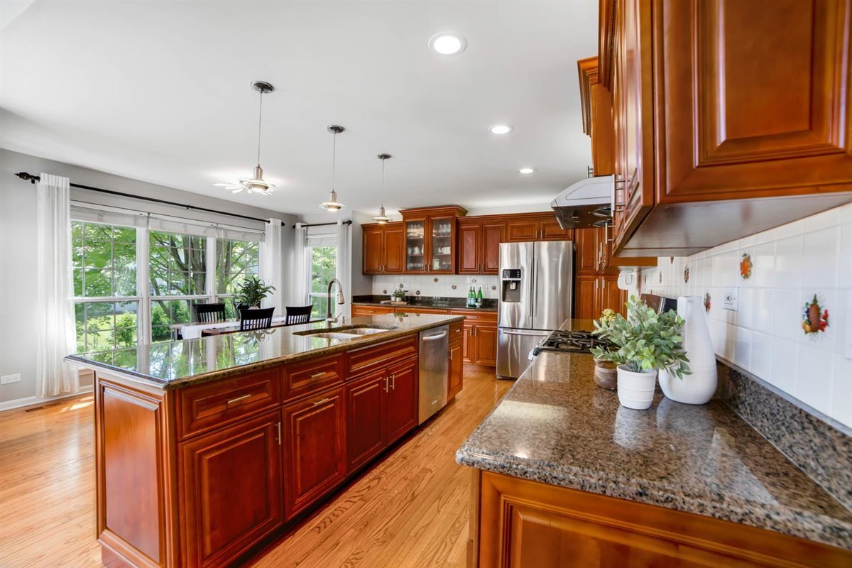 752 Sigmund Road Naperville, IL 60563 - Photo 14 of 55 a kitchen with lots of counter top space and wooden floor