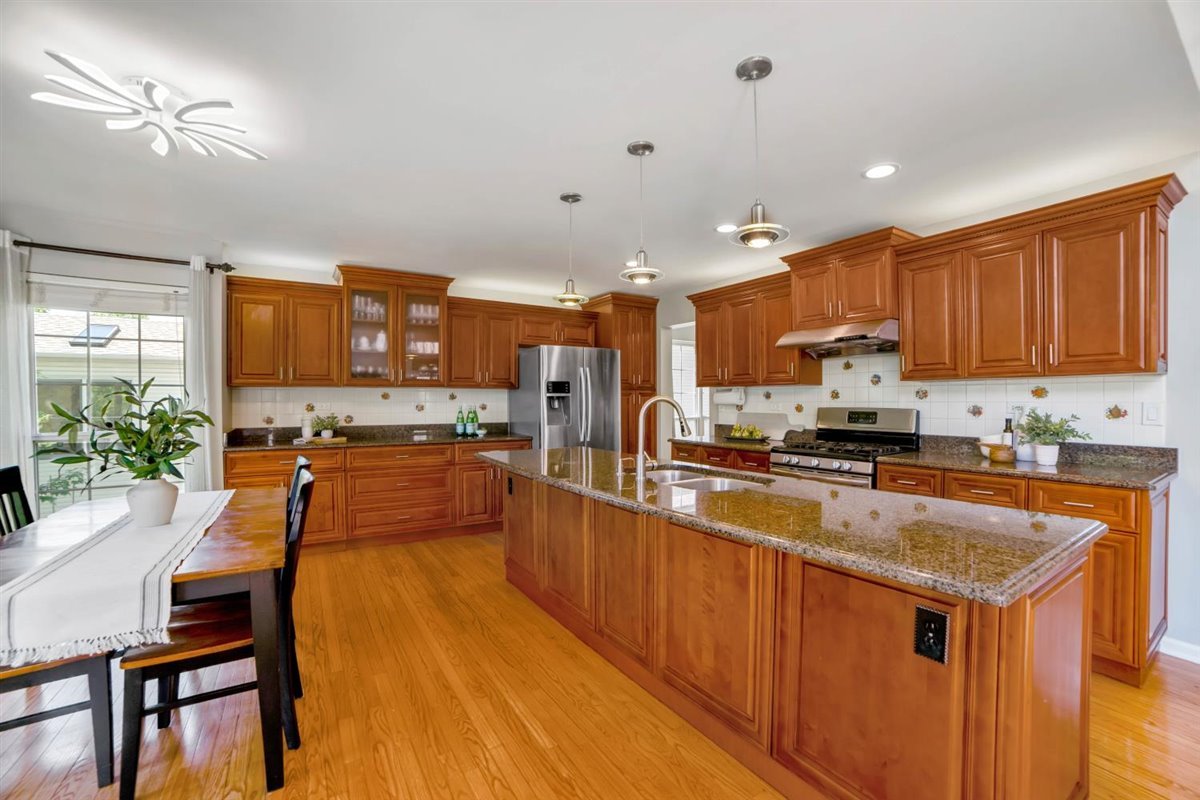 752 Sigmund Road Naperville, IL 60563 - Photo 15 of 55 a large kitchen with kitchen island a large counter top space a sink stainless steel appliances and cabinets