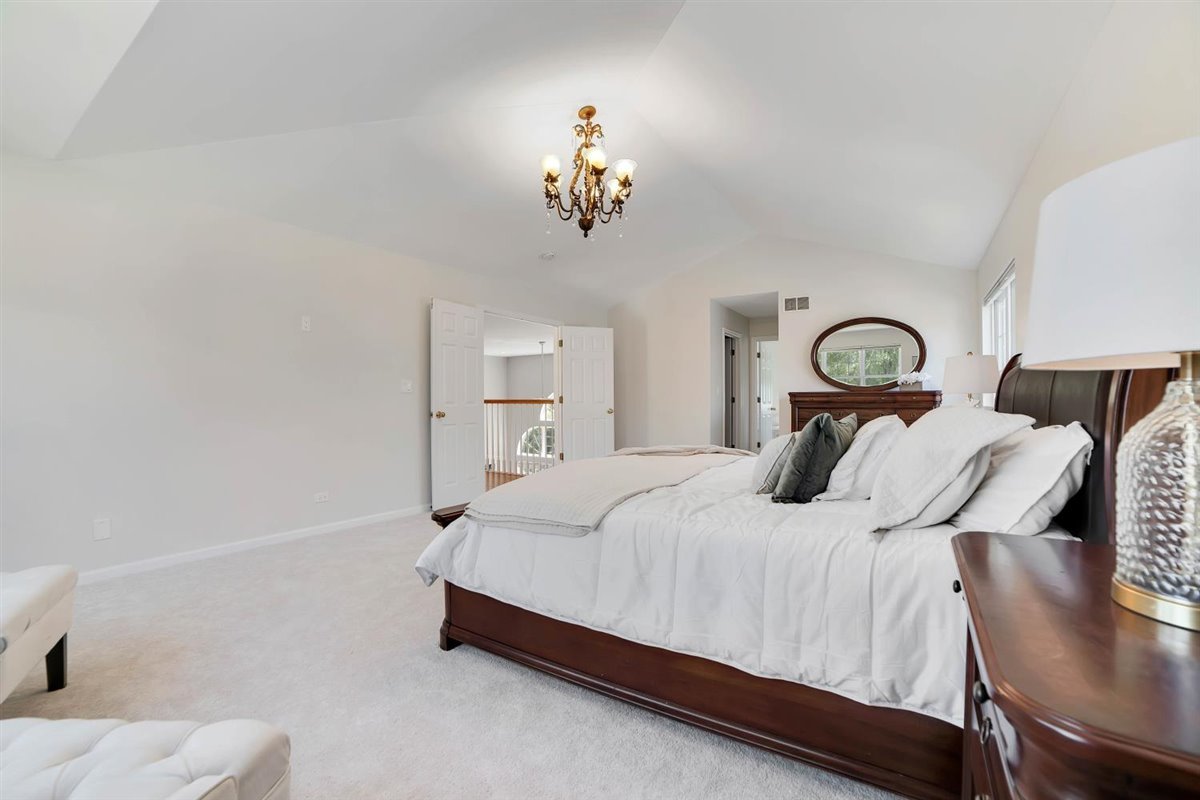 752 Sigmund Road Naperville, IL 60563 - Photo 30 of 55 a bedroom with a bed and chandelier