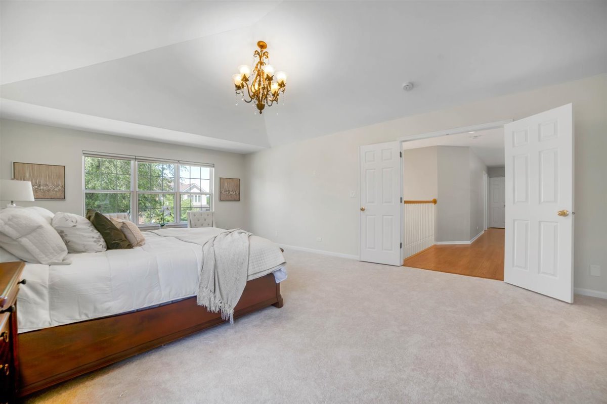 752 Sigmund Road Naperville, IL 60563 - Photo 31 of 55 a bedroom with a bed and a chandelier